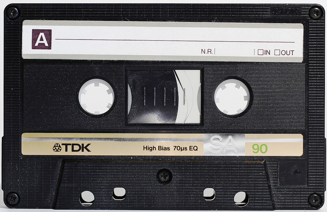 A compact audio cassette photographed on a white background